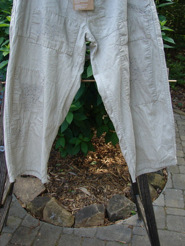 Magnolia Pearl NWT Patched Lilou Trouser Black Pinstripe OSFA hanging on a clothesline. Wider straight leg shape, overlay patches, front pockets, accent stitchery, distressed details. Reflects BlueFishFinder's vintage, creative style.