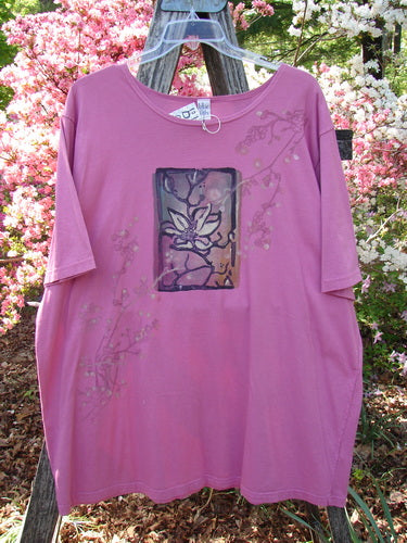 Barclay NWT Short Sleeved Studio Tee Single Cherry Blossom Alegra Size 3, featuring a flower motif on a loose-fit, organic cotton tunic with a wider neckline and larger sleeves, hung outdoors.