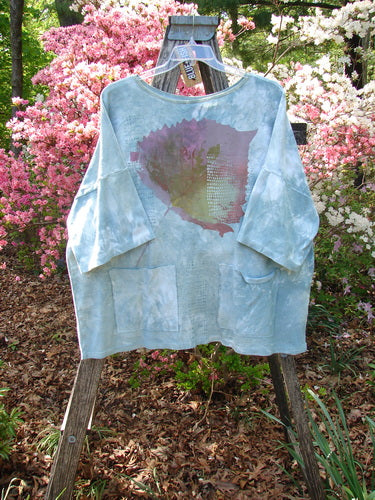 Barclay NWT Cotton Lycra Writer's Pocket Pullover Sweatshirt features a sky-blue shade with elbow-length sleeves, dual front pockets, and a large abstract leaf motif, emphasizing seamless design and creative expression.