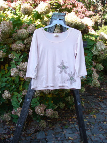 Barclay Cotton Lycra Three Quarter Sleeved A Line Tee Double Daisy Pink Tile Size 1: A pink shirt with flowers on a wooden stand.