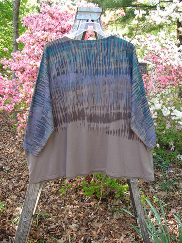 Barclay Cotton Lycra Writer's Pocket Pullover Sweatshirt Rear Rain Dark Bark OSFA features kimono-style sleeves, a shibori upper pattern, taupe lower half, dual pockets, and seamless design, hanging on a wooden ladder outdoors.