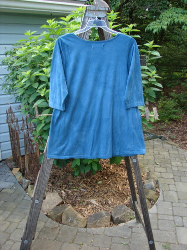 Barclay Modern Slim Tee Top Pansy Mottled Teal Size 1 displayed on a wooden rack, showcasing its three-quarter sleeves, slight hip flare, and rounded hemline.