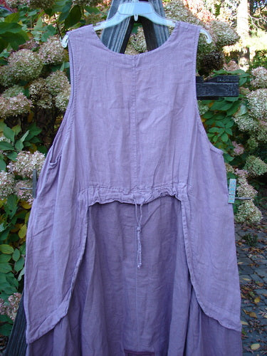 Barclay PMU Linen Explorer Jumper Pansy Lavender Size 2: A medium weight linen dress with a scoop neckline, billowy lower sweep, and a drawcord back. Features an exterior offset upper pocket and a signature patch rear center.