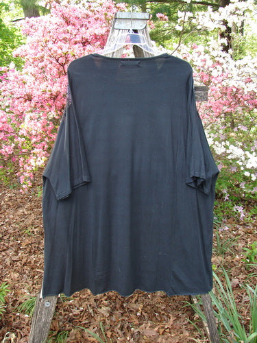 Barclay Art Tunic Tee Field Friends True Black OSFA draped on a wooden stand, showcasing its oversized design with drop shoulders, three-quarter sleeves, and an upward rounded front hem.