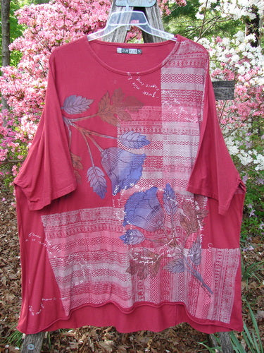 Barclay Art Tunic Tee Trailing Floral Deep Ruby OSFA features a loose fit, patchwork pattern, three-quarter sleeves, and rounded hem, showcasing botanical motifs in bluish-gray and tan on organic cotton.