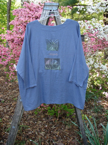1995 Silk Noile Long Sleeved Top Leaf Fish Butterfly Dusk OSFA draped on a rustic stepladder, showcasing its flowing, textured knit and abstract designs against a garden backdrop.
