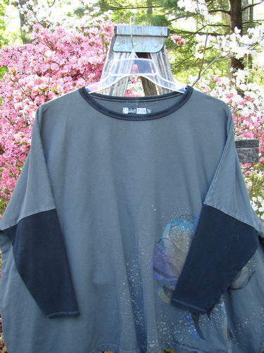 Barclay Cotton Lycra Rib Colors Contrast Sweatshirt in Peony Night Grey OSFA, featuring a wide boxy shape, contrasting neckline, dolman banded sleeves, and darker elbow patches, hanging outdoors among blooming flowers.