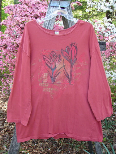 Barclay Long Sleeved Studio Tee Double Crocus Harvest Size 2 hangs on a trellis, showcasing its organic cotton fabric with dark rose blossoms and gold accents, embodying Bluefishfinder.com’s unique, expressive vintage style.