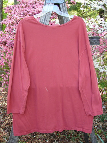 Barclay Long Sleeved Studio Tee Double Crocus Harvest Size 2, crafted from medium-weight organic cotton, hangs on a wooden stepladder, showcasing its straight shape, cozy long sleeves, and rounded neckline.