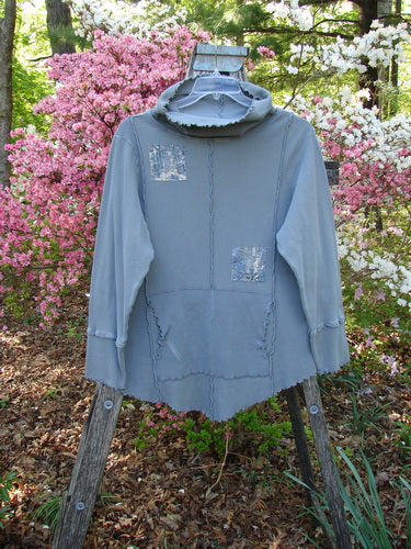 Barclay Patched Thermal Cowl Neck Roo Tunic Gray Day Size 1 with exposed seams, silver-tone patches, ribbed cuffs, curly edgings, and a loose cowl neck, displayed on a wooden ladder.