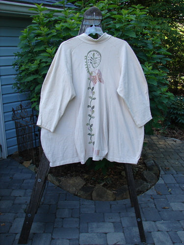 1996 Reprocessed Spring Rain Jacket Garden Vine Birch Bark OSFA displayed on a hanger, showcasing its vintage closure, A-line shape, deep side pockets, and detailed garden vine theme paint.