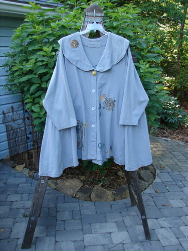 1994 PMU Wanderer's Jacket English Garden Solstice Blue Size 2 displayed on a rack, showcasing its wide shawl collar, sectional side inserts, and vintage top button detailing.