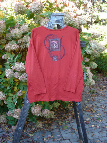A red long-sleeved tee with a Geisha Gal theme paint design, featuring a rounded neckline and cozy sleeves. Made from organic cotton, this Barclay Long Sleeved Tee is from the Fall Collection in Geisha's Robe. Bust 50, Waist 50, Hips 50, Length 30 inches.