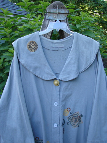1994 PMU Wanderer's Jacket English Garden Solstice Blue Size 2 displayed on a swinging hanger, showcasing a wide shawl collar, sectional side inserts, and a unique front button detail.