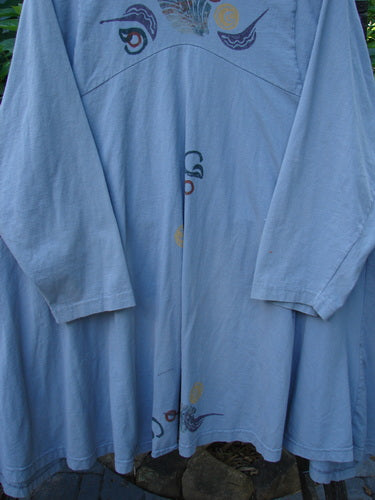 Alt text: 1994 PMU Wanderer's Jacket English Garden Solstice Blue Size 2 on a clothes rack, showcasing its wide shawl collar, sectional side inserts, and vintage top button.