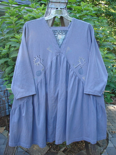 Alt text: 1996 Gypsy Dress Abstract Face Mulberry Size 2 with crisscross and gathered design, squared neckline, and painted panel, displayed on a clothes rack.