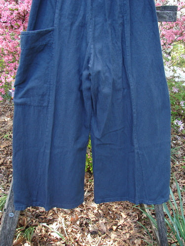 Barclay Heavy Linen Single Side Pocket Pant Unpainted Navy Generous Size 0 draped over a small wooden ladder, showcasing its wide-leg design, full elastic waistline, and distinctive side wrap pocket.