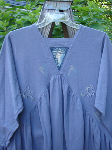 1996 Gypsy Dress Abstract Face Mulberry Size 2. Features a crisscross and gathered vertical front and back, with a painted triangular panel and abstract face theme. Shortened sleeves, organic cotton.