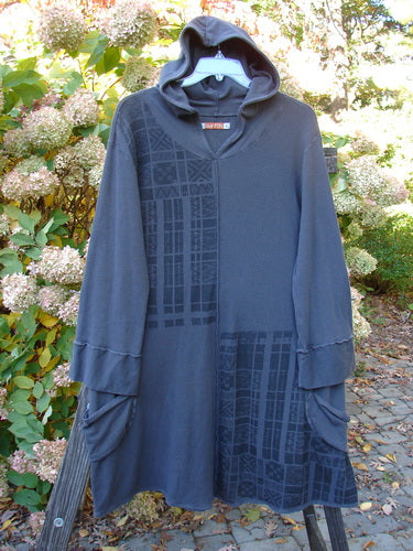 Barclay Thermal Hooded Pocket Tunic in Slate, a long black hooded robe with a long sleeved blue shirt underneath, featuring a close-up of a flower.