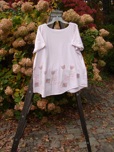 Image alt text: Barclay Short Sleeved Pocket Top with tulip theme paint, widening A-line flair, and exterior scoop pocket. Size 1, Orchid color.