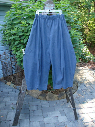 A pair of Barclay Light Weight Denim Crop 4 Square Pant Unpainted Indigo Size 2 on a clothes rack, showcasing the unique 3D diamond cut from the knee down and billowy bottom.