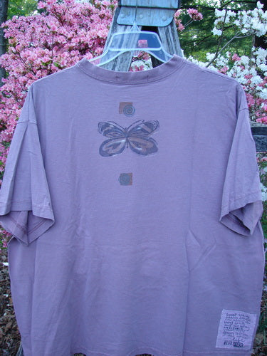 1996 Short Sleeved Tee Triple Butterfly Petal Size 2 hanging with a butterfly graphic on the back, showcasing a vintage boxy fit with a ribbed neckline and drop shoulders.