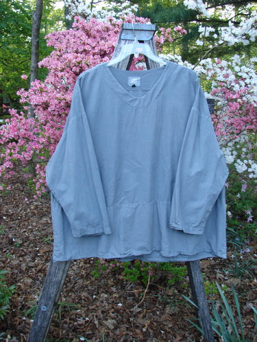 2000 Percal Overshirt Top Unpainted Eucalyptus Size 2 displayed on an outdoor wooden ladder, showcasing its light, airy featherweight cotton percale with a drop waist seam, softly rounded V-neckline, and drop shoulders.