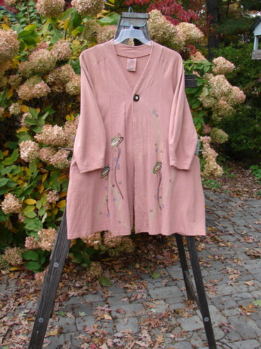 A 1996 Reprocessed Spring Rain Jacket in Petal, altered and in perfect condition. Features include a vintage closure, A-line shape, deep side pockets, and detailed paint and belled side accents. Bust 40, Waist 46, Hips 56, Length 38.