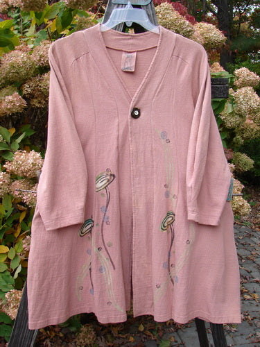 A 1996 Reprocessed Spring Rain Jacket in Petal, altered and in perfect condition. Features include a vintage closure, A-line shape, deep side pockets, and detailed paint and belled side accents. Bust 40, waist 46, hips 56, length 38 inches.