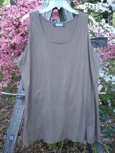Barclay Lightweight Basic Tank Top Unpainted Dusty Bark Smaller Size 2 displayed on a clear hanger against a rustic wooden ladder, highlighting its straight bodice and rounded neckline in an outdoor setting.