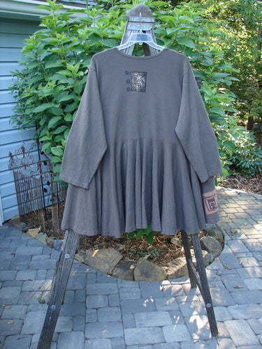 Alt text: 1994 Reprocessed Dance Dress Belief Spirit Magic Humus OSFA, a grey long-sleeved shirt with a swingy lower, drop waist, and heavy bottom, displayed on a hanger.