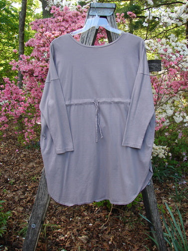 Barclay Long Sleeved Pop Top Celtic Spirograph Stone Size 1 features an oversized exterior pocket with a textured button, displayed on a ladder amidst a garden setting, highlighting its relaxed, artistic style.