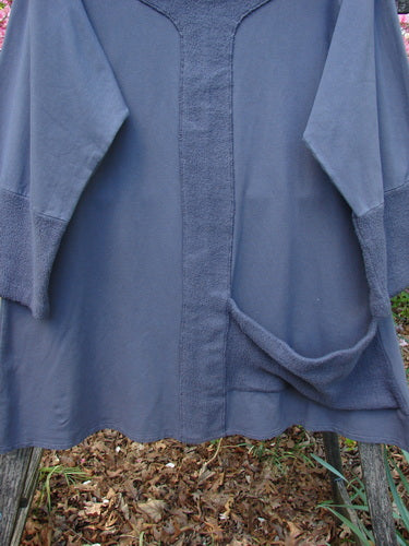 Barclay Cotton Lycra Celtic Moss Single Pocket Tunic Unpainted Grey Plum Size 1 on a garden bench, featuring a textured front panel, loose sleeves, and a side pocket, surrounded by fallen leaves.
