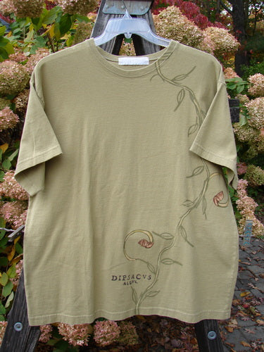 1998 Botanicals Short Sleeved Tee Continuous Vine Seed Size 1: A t-shirt with a design on it featuring a continuous vine theme paint, a thicker ribbed neckline, and a fairly straight shape. Made from medium weight organic cotton jersey.