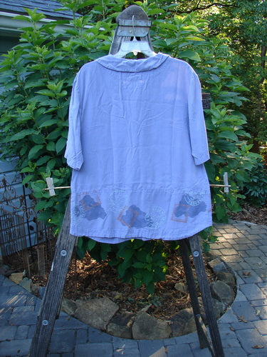 2000 Tencel Camp Shirt Airmail Twilight Size 0 displayed on a clothes rack, showcasing its Peter Pan collar, oversized buttons, front drop pocket, and full paneled sweep.