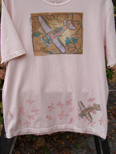 2001 Short Sleeved Tee Airplane Pink Tile Size 0: A pink t-shirt with a picture of an airplane, made from organic cotton. Features drop shoulders and a slightly longer length.