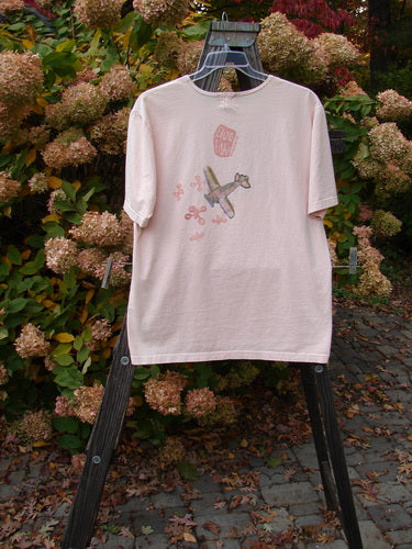 2001 Short Sleeved Tee Airplane Pink Tile Size 0: A pink shirt with an airplane design on it, made from organic cotton. Slightly longer length, drop shoulders, and ribbed neckline. Perfect condition.