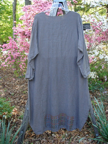 Barclay Linen Tea Ceremony Thostle Dress Cross Grid Dark Stone Size 1, hanging from a ladder, showcases a rolled neckline, hourglass shape, upward scoop hemline, and offset pockets, embodying Bluefishfinder.com's unique vintage style.