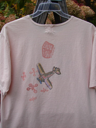 2001 Short Sleeved Tee Airplane Pink Tile Size 0: A shirt with an airplane theme paint design, made from mid-weight organic cotton. Slightly thicker ribbed neckline, drop shoulders, and slightly longer length. Perfect condition.