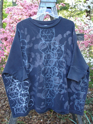 Barclay Fleece Banded Sleeve Dolman Top showcases a generous boxy shape with dolman sleeves, spirograph pattern, and banded hem, draped over a wooden ladder.