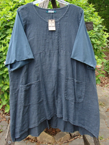 Barclay NWT Linen Cotton Sleeve Milkmaid Dress Unpainted Blue Cypress Size 2, featuring a loose fit, round neckline with pleats, elbow-length sleeves, large front pockets, displayed outdoors.