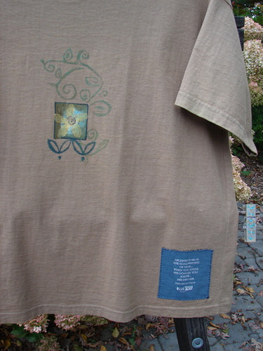 1997 Short Sleeved Tee with Spirit Drum design. Close-up of a t-shirt featuring a fair straight shape, ribbed neckline, and Blue Fish patch. Made from organic cotton.