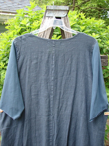 Barclay NWT Linen Cotton Sleeve Milkmaid Dress in Blue Cypress hangs on a ladder, showcasing its loose fit, three-quarter sleeves, and empire waist seam, embodying Bluefishfinder.com's vintage-inspired style.