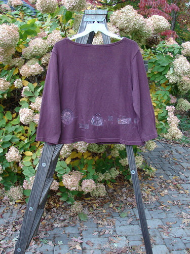 A purple Barclay Textured Cotton Crop Box Sweater with a stain on it, displayed on a wooden rack.