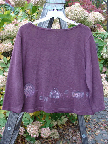 Barclay Textured Cotton Crop Box Sweater Travel Deep Rose Size 0: A purple shirt with drawings on it, featuring a wide and deep neckline, four tiny button closure, boxier shape, cozy sleeves, and textured cotton knit with travel theme paint throughout.