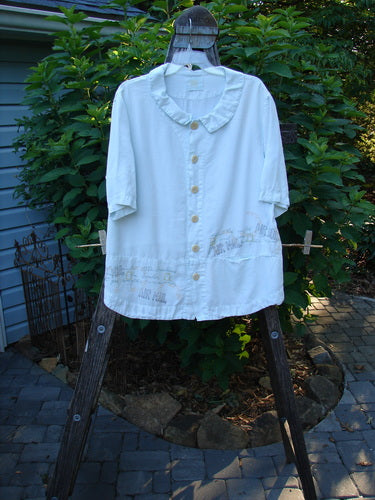 2000 Tencel Camp Shirt Airmail Shark Size 0 on a clothes rack, featuring a smaller Peter Pan collar, oversized buttons, a front drop pocket, and a full paneled sweep.