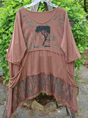 Barclay Raw Seam Vector Tunic Dress Single Tree Redwood Size 2 displayed on a hanger outdoors, featuring a bohemian style with a tiered design, raw edges, a silhouette tree graphic, and draped pockets.