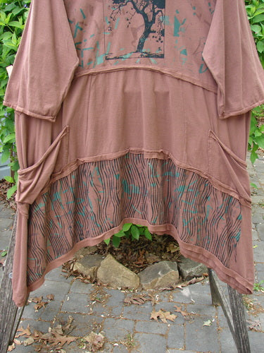 Barclay Raw Seam Vector Tunic Dress Single Tree Redwood Size 2 draped over a bench, featuring a tree graphic, slouchy side pockets, and an asymmetrical hem with striped lower print.