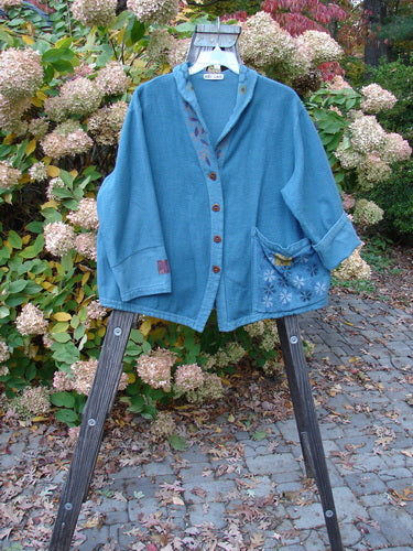A Barclay Patched Flannel Frolic Jacket in Ocean Teal with garden-themed patches, ribbed cord accents, and an oversized exterior pocket. Size 0.