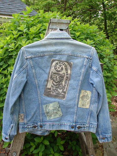 1995 Patched Levi Strauss & Co Denim Blue Jean Jacket Kitty Kitty Stone Wash Size 0, featuring whimsical animal patches, displayed on a wooden ladder amidst greenery, showcasing vintage style and unique customization.